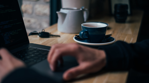 Person drinking a hat drink at the computer